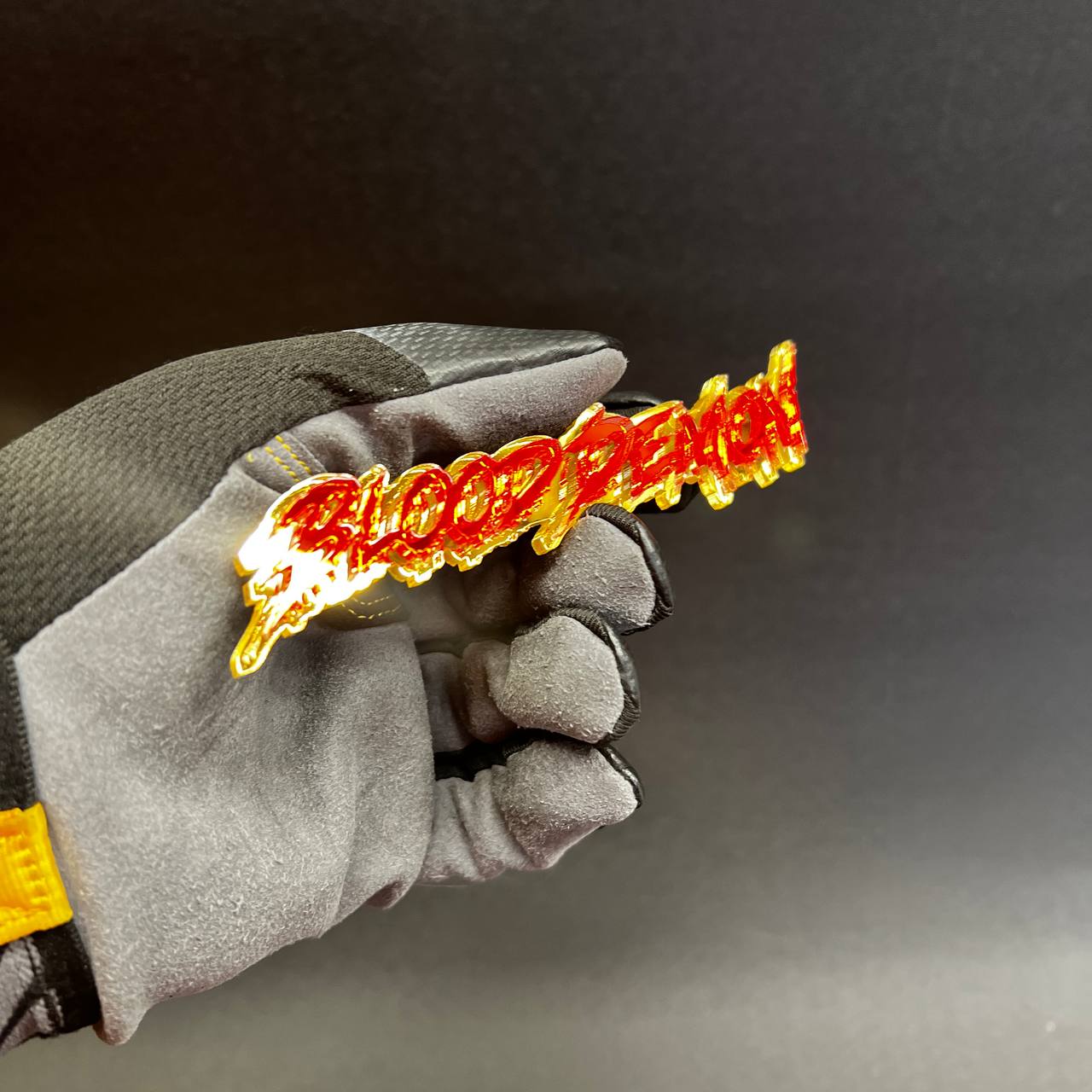 Custom acrylic car badge with aggressive dripping font style in reflective red and gold finish