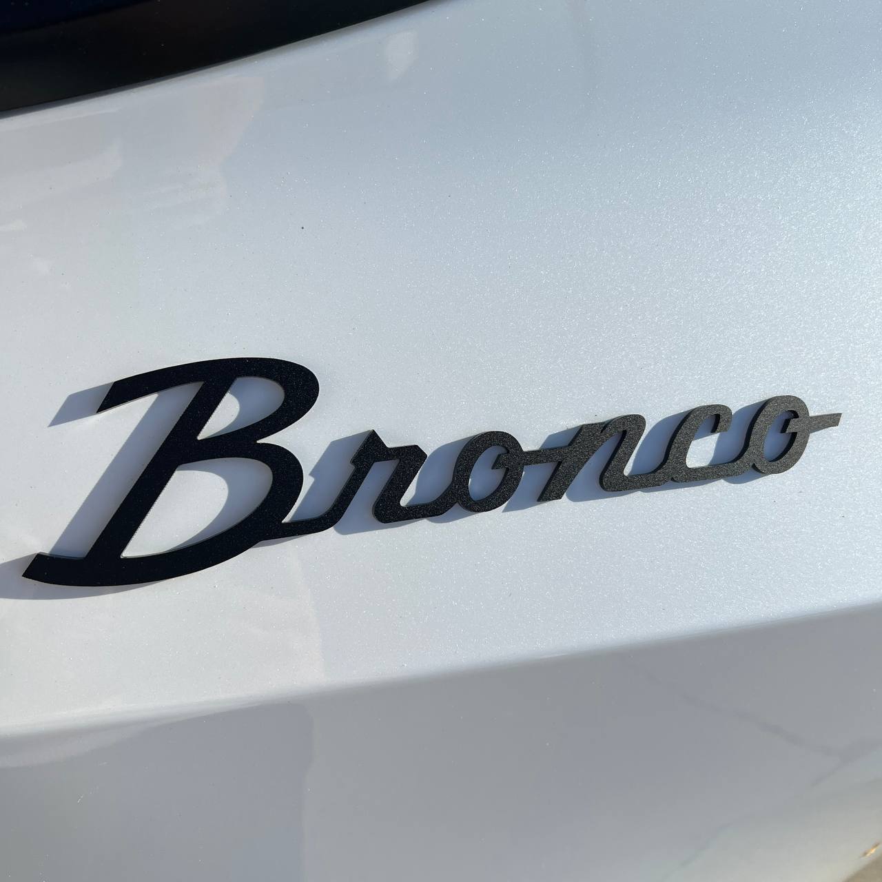 Pair of black acrylic script-style badges with layered 3D effect