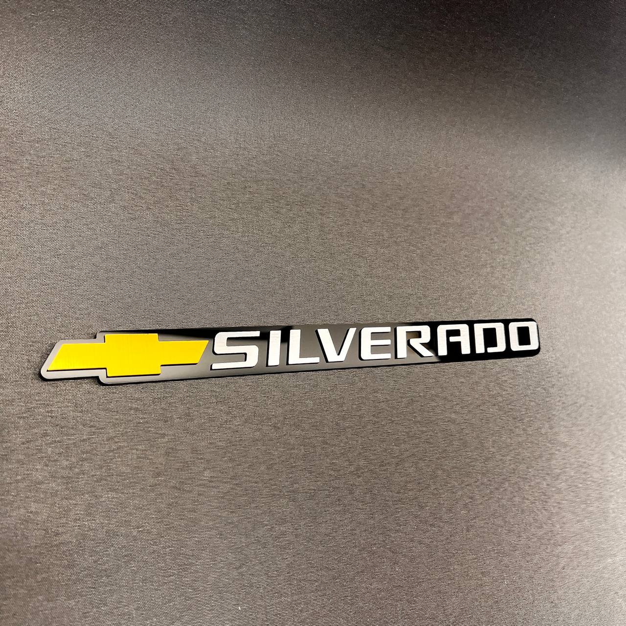 Custom Chevrolet Silverado tailgate badge featuring gold bowtie logo and white lettering.