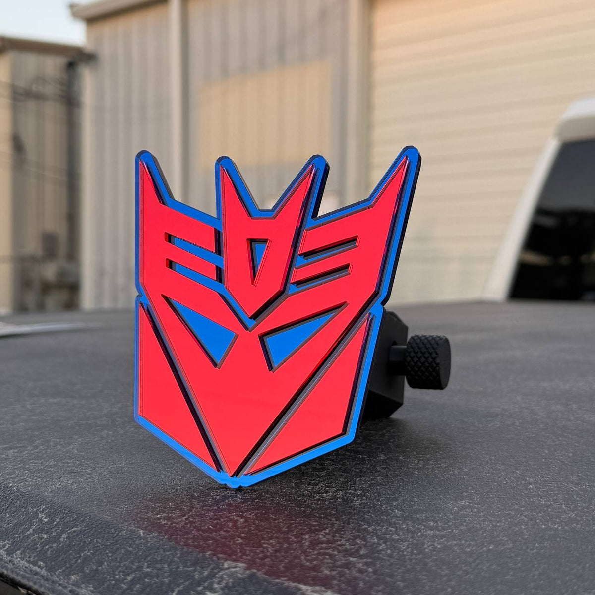 Decepticon Transformers trailer hitch receiver cover accessory for Chevrolet Silverado trucks.