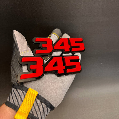 Fast 345 car emblem shown in hand with red top layer and black base