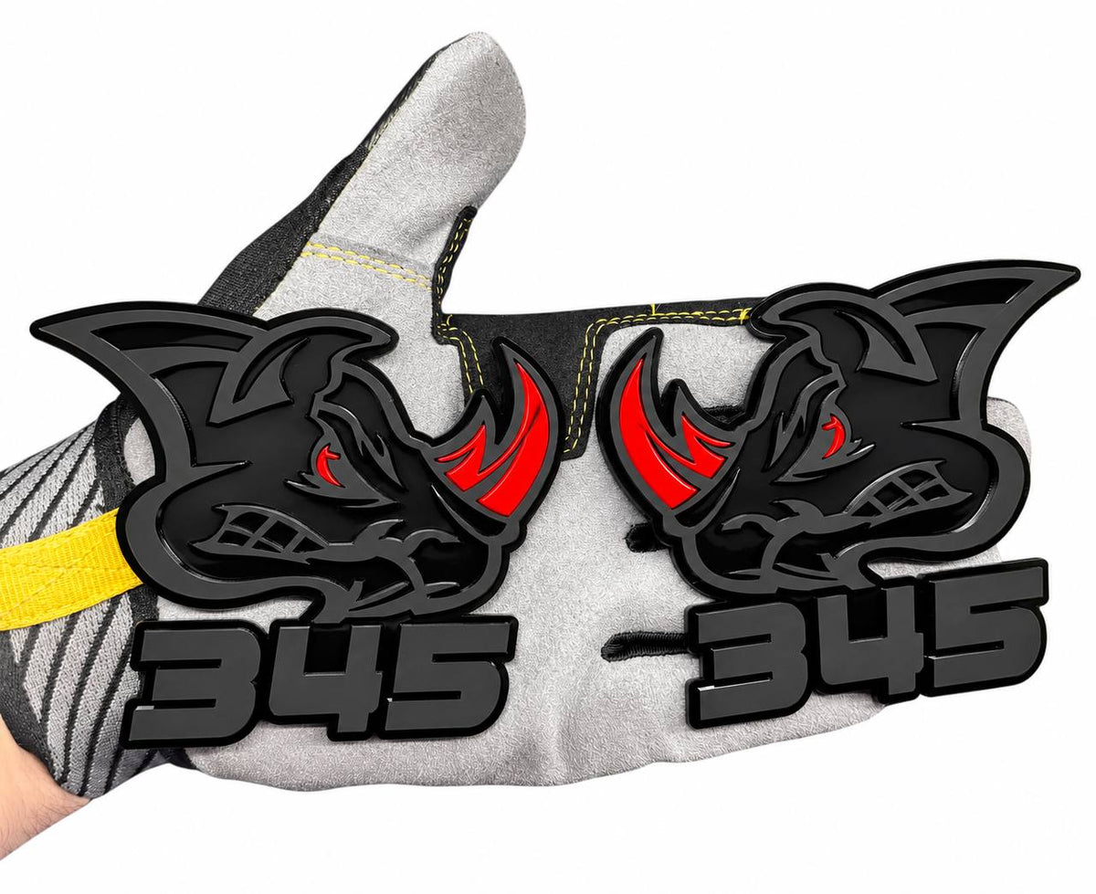 345 Rhino matte black car badge featuring an aggressive rhinoceros design with a bright red eye and red horn, custom automotive fender emblem.