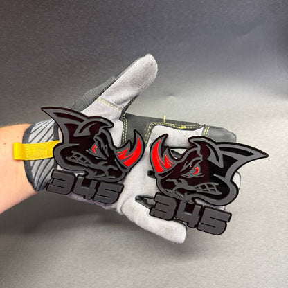 Black 345 Rhino car badge with aggressive rhinoceros face, red horn and red eye, decorative fender or tailgate emblem for muscle cars.
