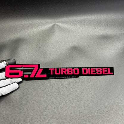 6.7L Turbo Diesel High Output acrylic badge in red and black for heavy duty diesel truck styling.