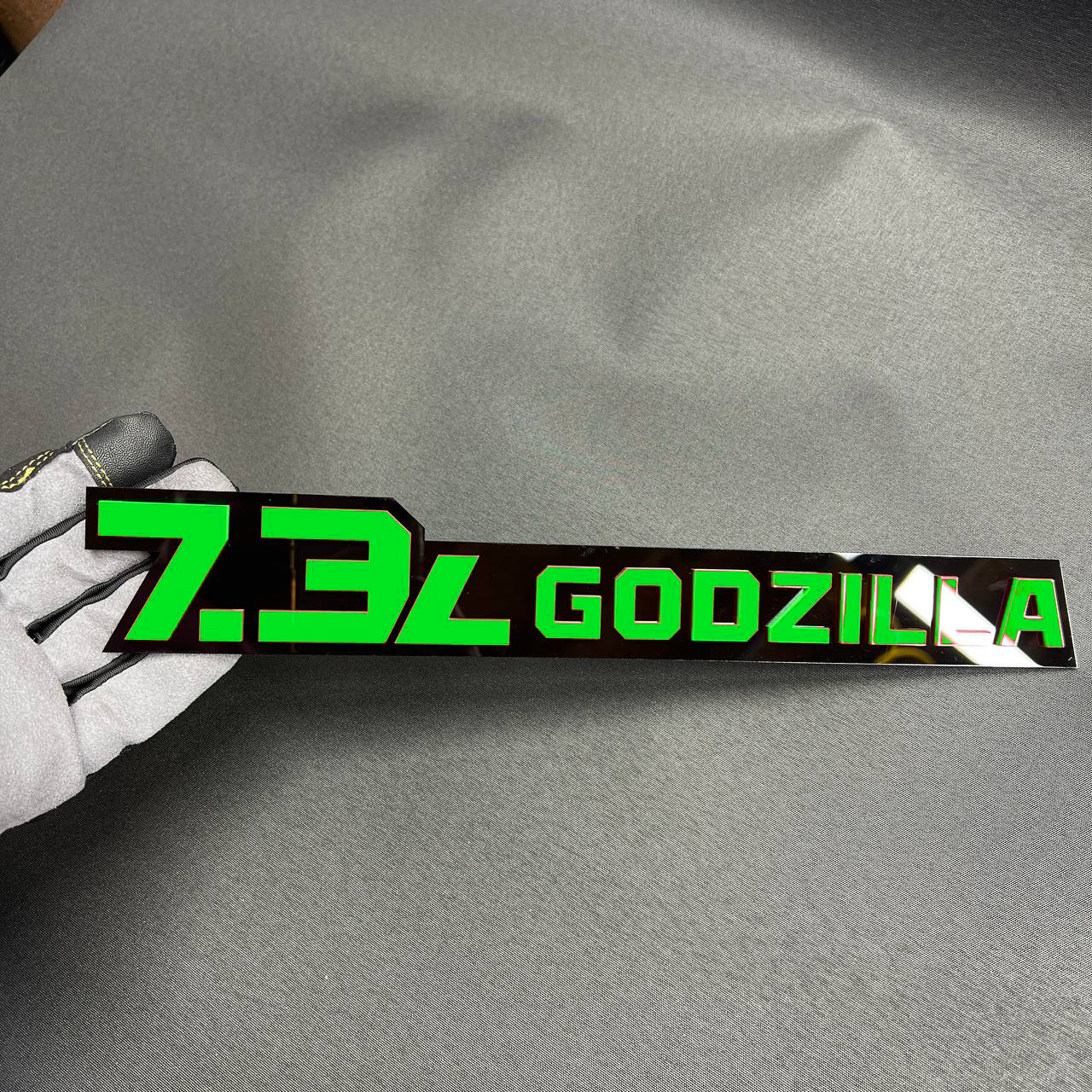 Custom 7.3L Godzilla engine badge made from layered acrylic for Ford F250 and F350 trucks.