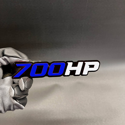 Light blue and white 700HP badge with bold black outline