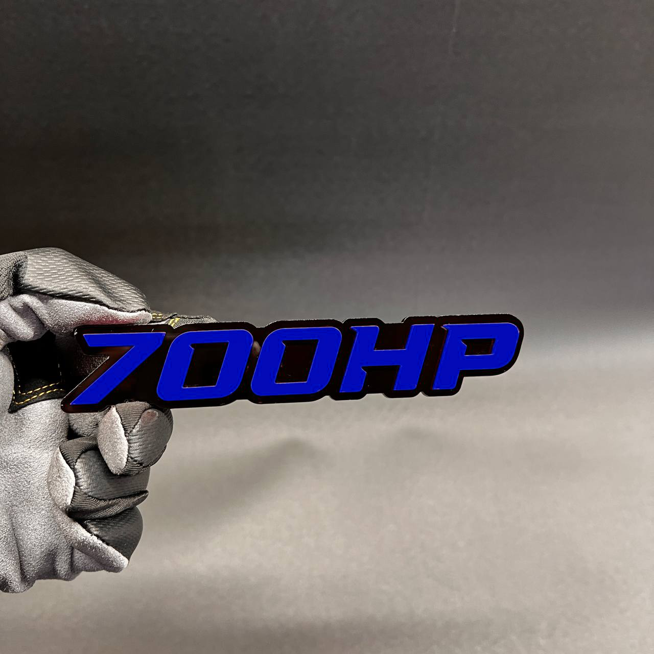 Handcrafted 700HP horsepower badge with red top layer and black base