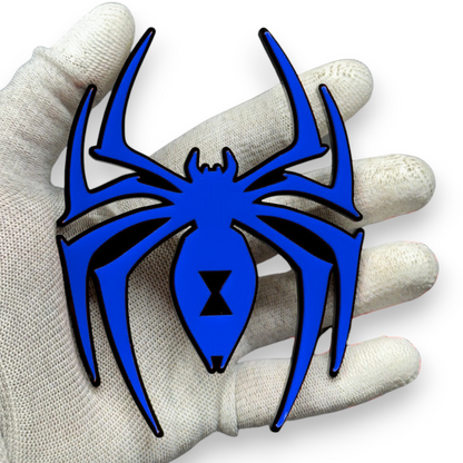Close up of black widow spider acrylic car badge showing hourglass symbol, glossy red finish, sharp edges, and layered automotive emblem detail