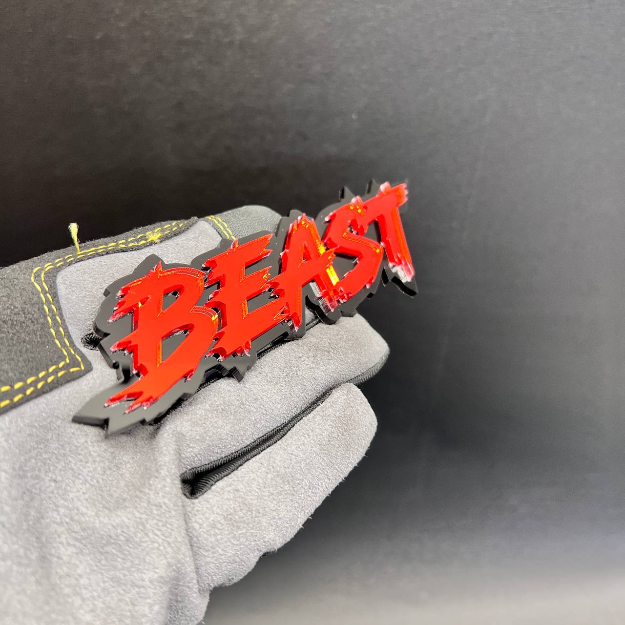 Aggressive BEAST automotive emblem with sharp distressed lettering