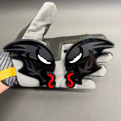 Custom ALIEN head car badge featuring glossy black layered detailing, white eyes and red tongue, designed as an aggressive aftermarket automotive emblem.