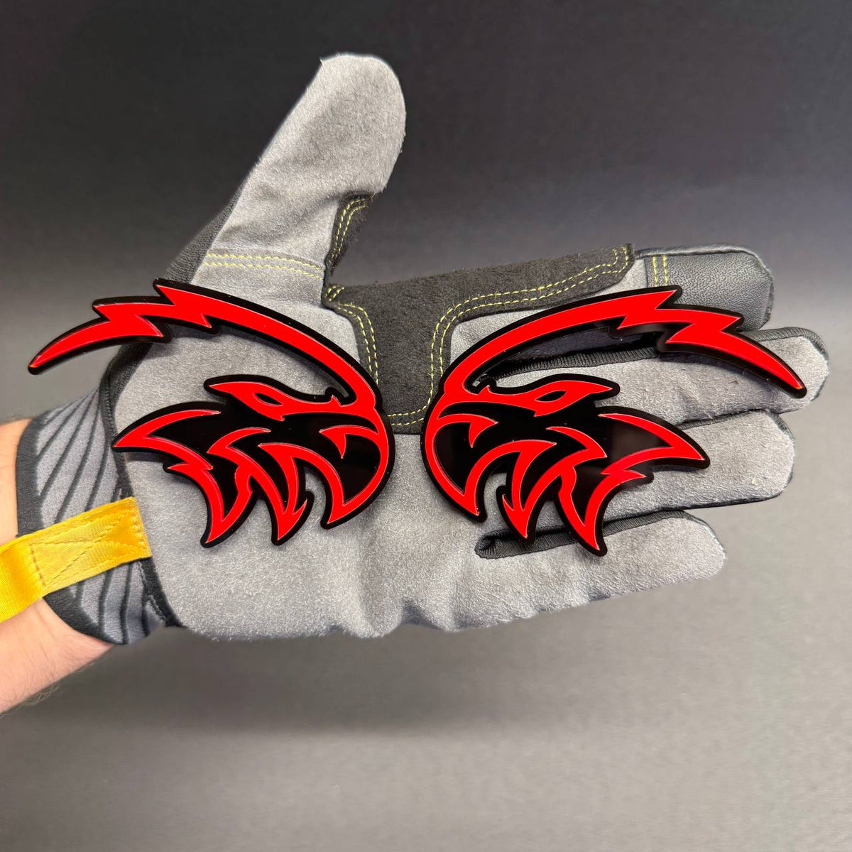 Pair of Angry Falcon car badges in red and black featuring aggressive falcon head designs for custom fender, grille or tailgate styling.