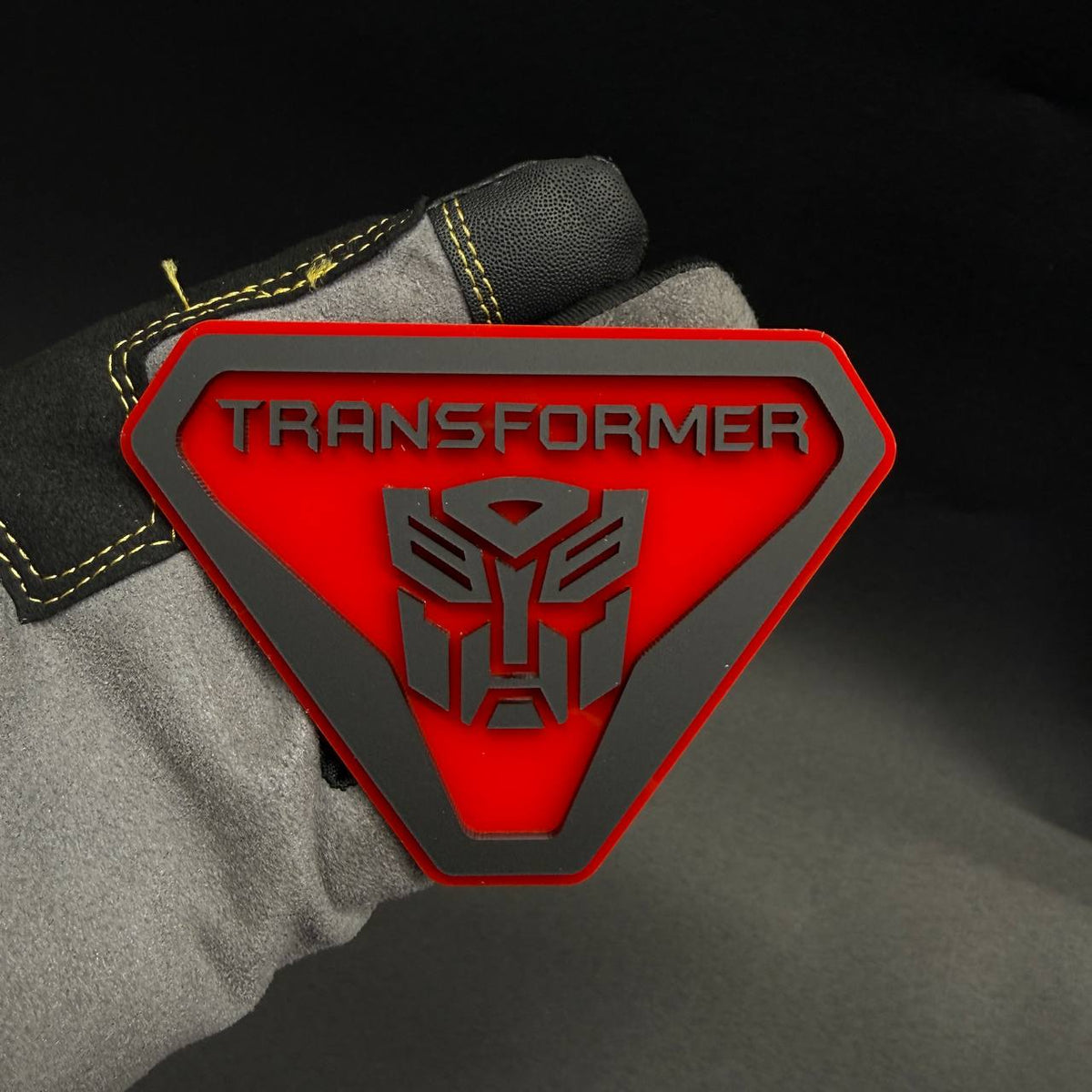 Red and silver Autobot logo vehicle badge for Ford, Jeep, Dodge, RAM, Chevrolet and GMC automotive styling.