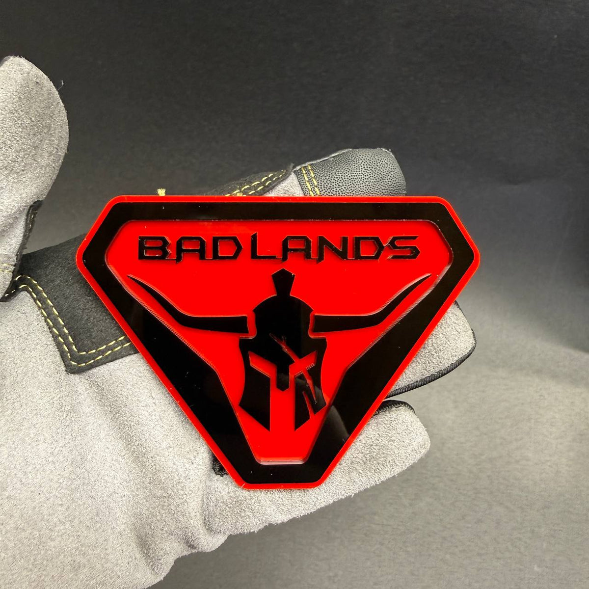 Red and black Badlands Gladiator car badge for off-road truck SUV fender customization.