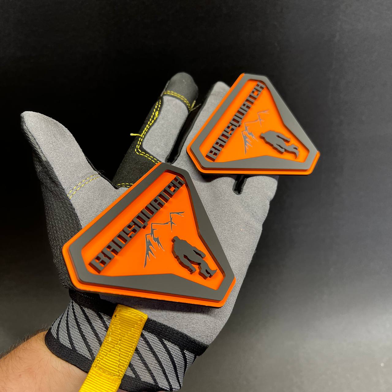 Orange and gray BadSquatch car emblem with mountain design