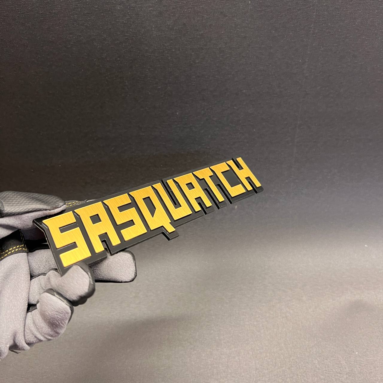 Bigfoot inspired vehicle emblem with black base and yellow top layer