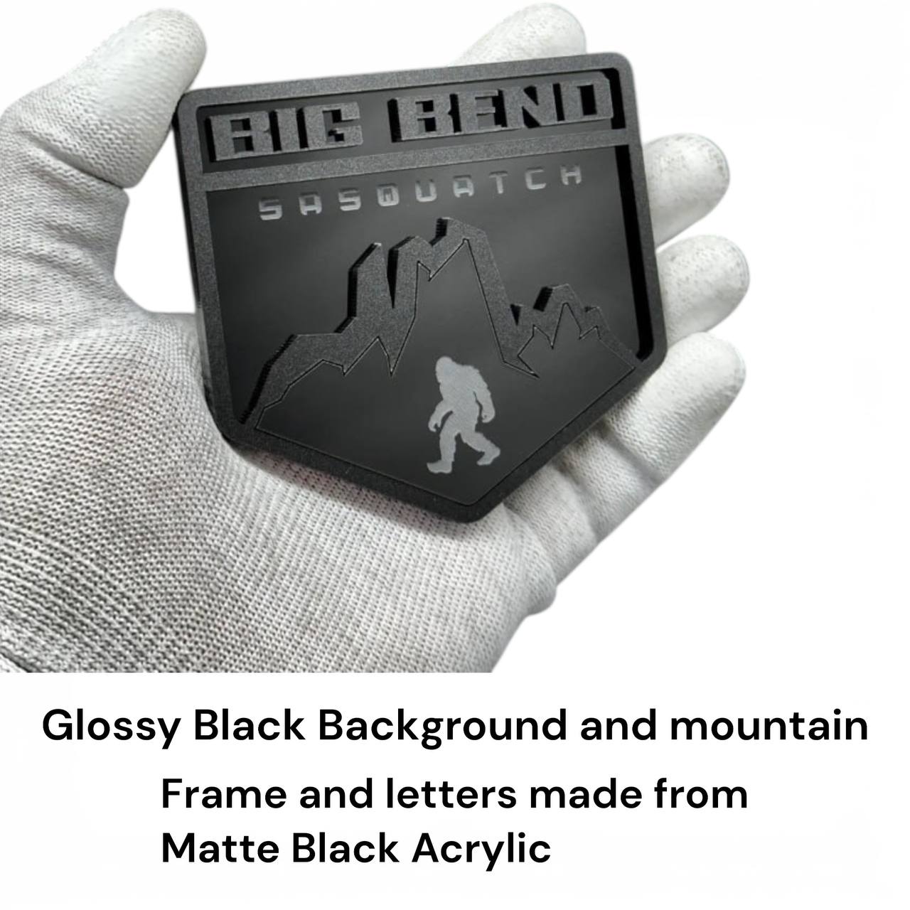 Matte and gloss black acrylic mountain badge detail with layered 3D design Sasquatch engraved