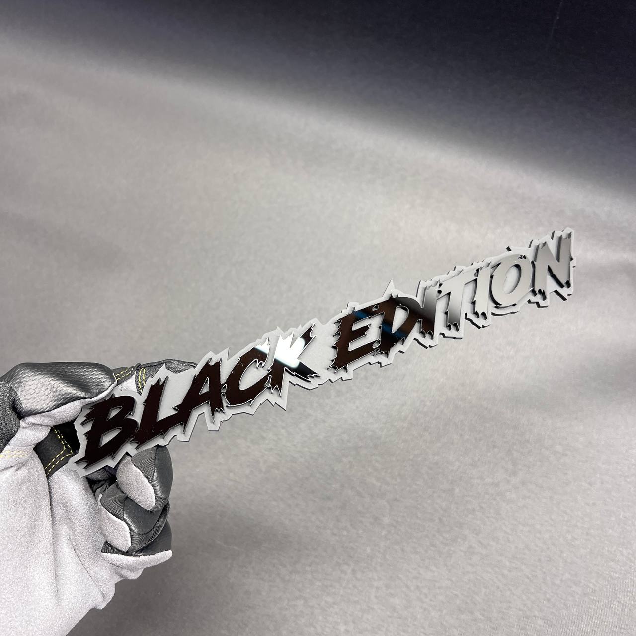 Matte black Black Edition vehicle emblem with bold jagged lettering