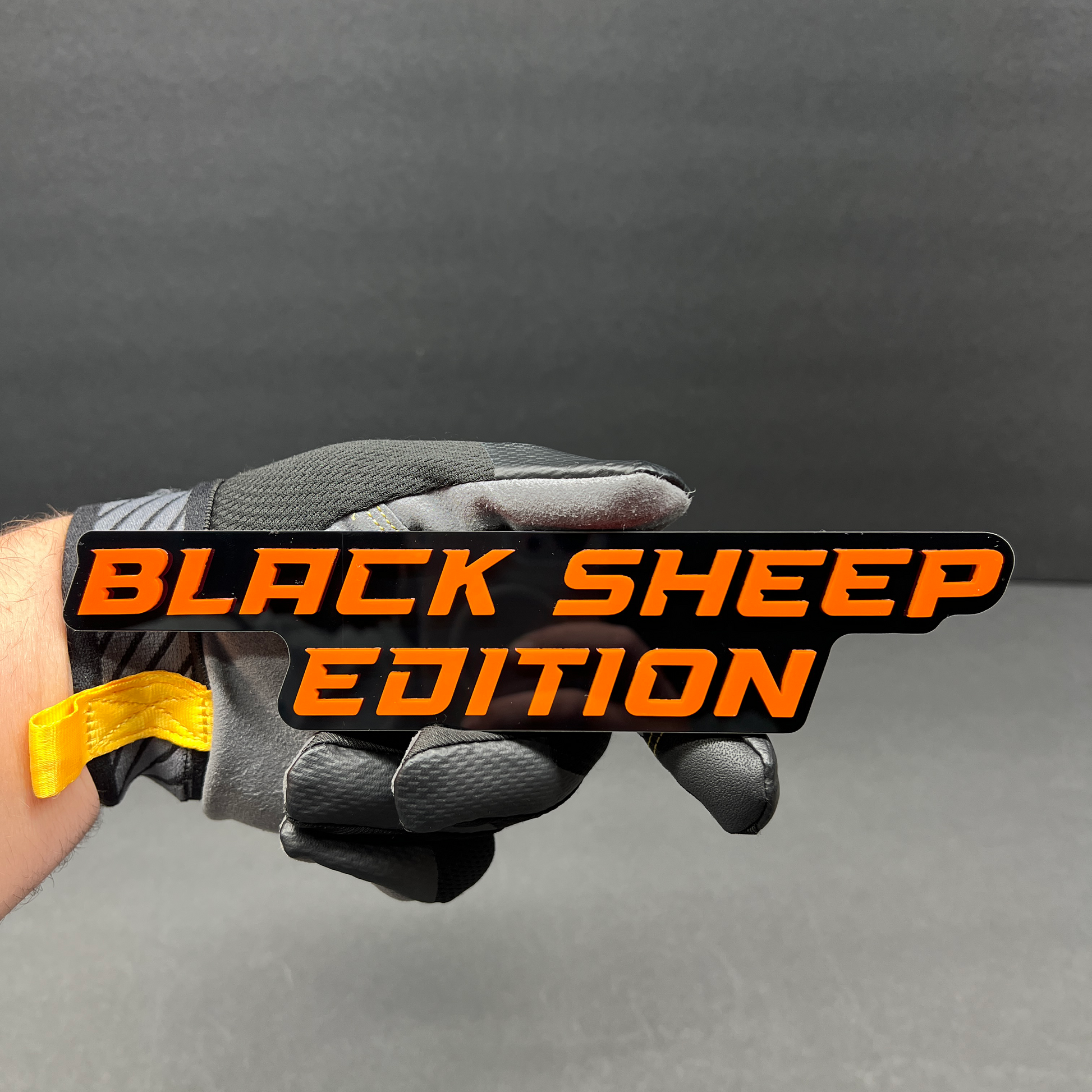 Custom Black Sheep Edition badge with bold red lettering on black acrylic.