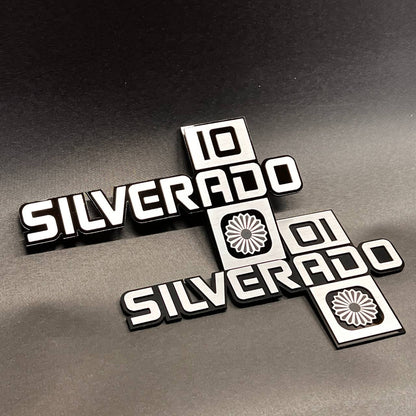 Silverado truck side badge with bold raised lettering and decorative icon