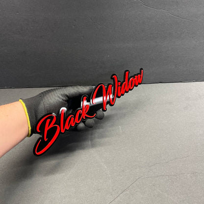 Close-up of Black Widow 3D acrylic racing emblem showing sharp drip lettering details