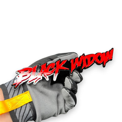 Black Widow red drip automotive emblem held in hand, glossy acrylic finish