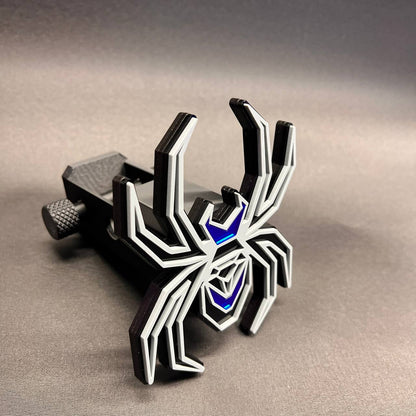 Gray on black Black Widow spider car badge with reflective mirror blue accent sections.
