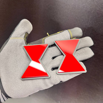 Two matching Black Widow symbol vehicle emblems shown on a gloved hand for scale