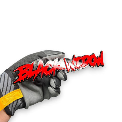 Black Widow red drip automotive emblem held in hand, glossy acrylic finish