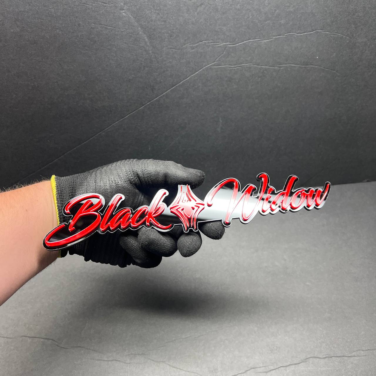 Front view of Black Widow custom acrylic car badge with red and black layered design