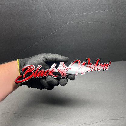 Front view of Black Widow custom acrylic car badge with red and black layered design