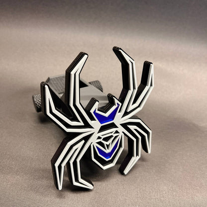Black Widow spider receiver hitch cover with gray detailing and reflective blue accents.
