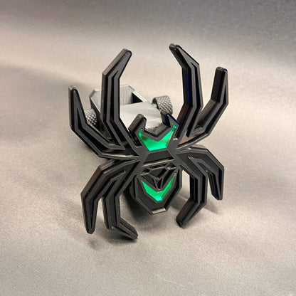 Decorative Black Widow spider receiver hitch cover in black and green automotive styling.