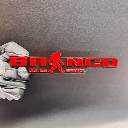 Red Bronco Outer Banks car emblem with Sasquatch silhouette and black background