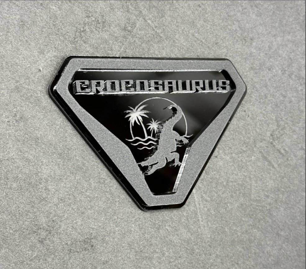 Side angle view of crocodile and alligator Crocosaurus badge on Ford Bronco off-road vehicle