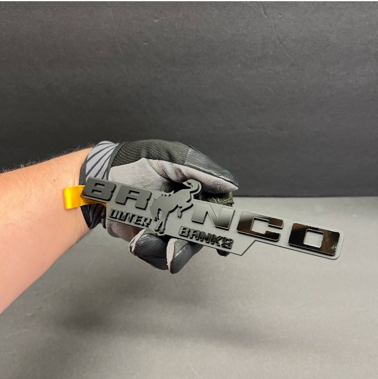BRONCO Outer Banks truck exterior badge emblem in gray finish, custom raised acrylic style.