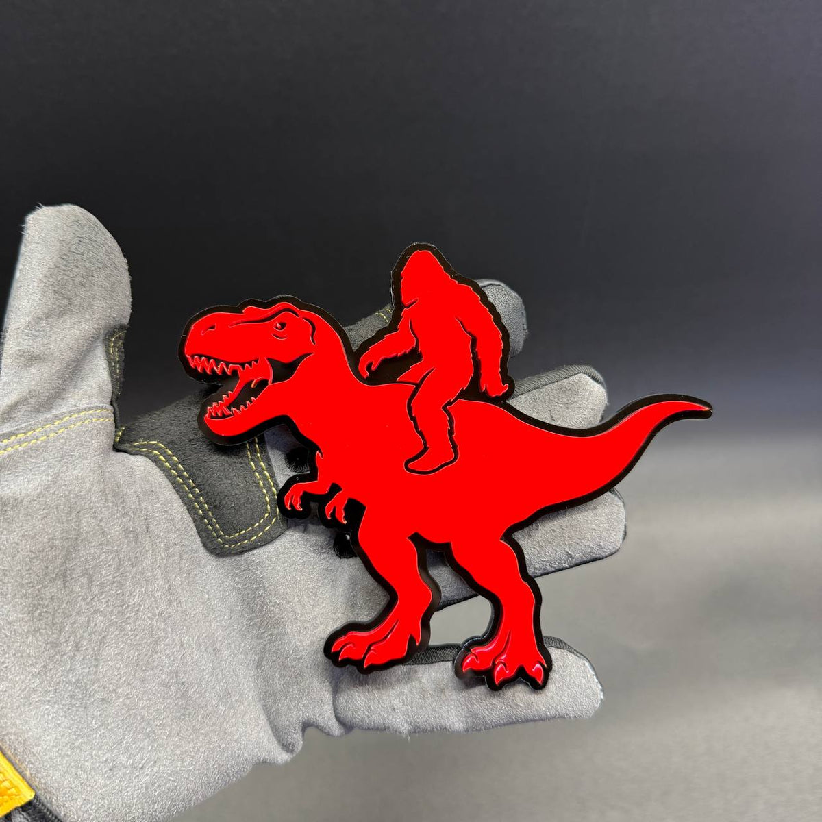 Bronco Raptor Sasquatch riding dinosaur automotive badge with red and black finish