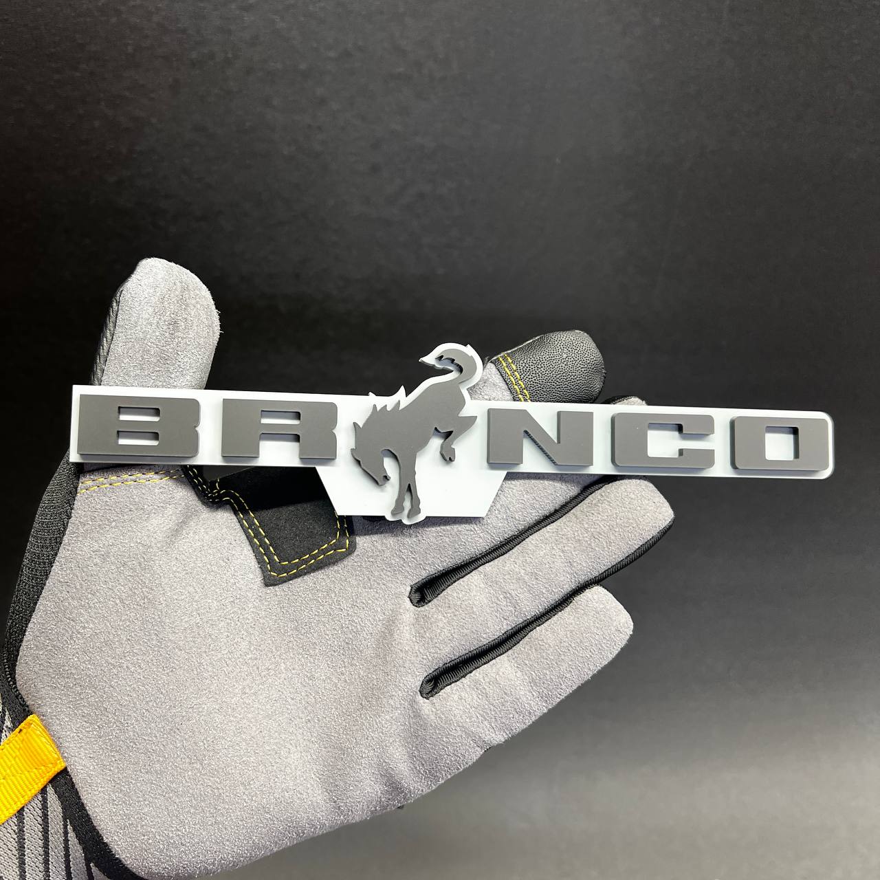 Bronco off-road SUV badge in gray and white color combination
