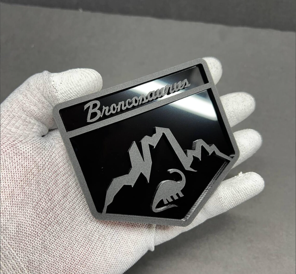Custom Broncosaurus Ford Bronco badge shown in hand to display size and premium acrylic finish
