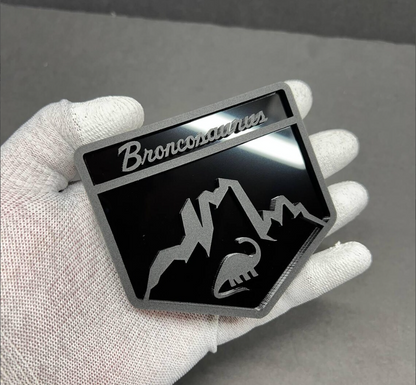 Custom Broncosaurus Ford Bronco badge shown in hand to display size and premium acrylic finish