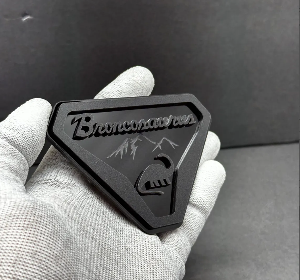 Laser-cut acrylic Broncosaurus badge designed for Ford Bronco off-road and adventure vehicles