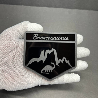 Close-up of Broncosaurus dinosaur emblem for Ford Bronco with mountain design and engraved details