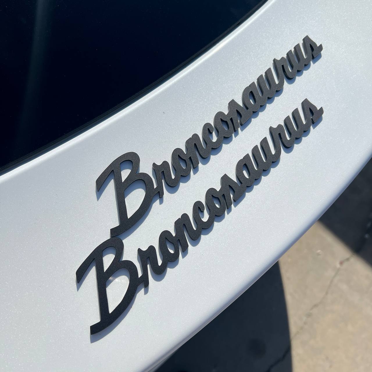 Broncosaurus vehicle badge designed for custom exterior styling