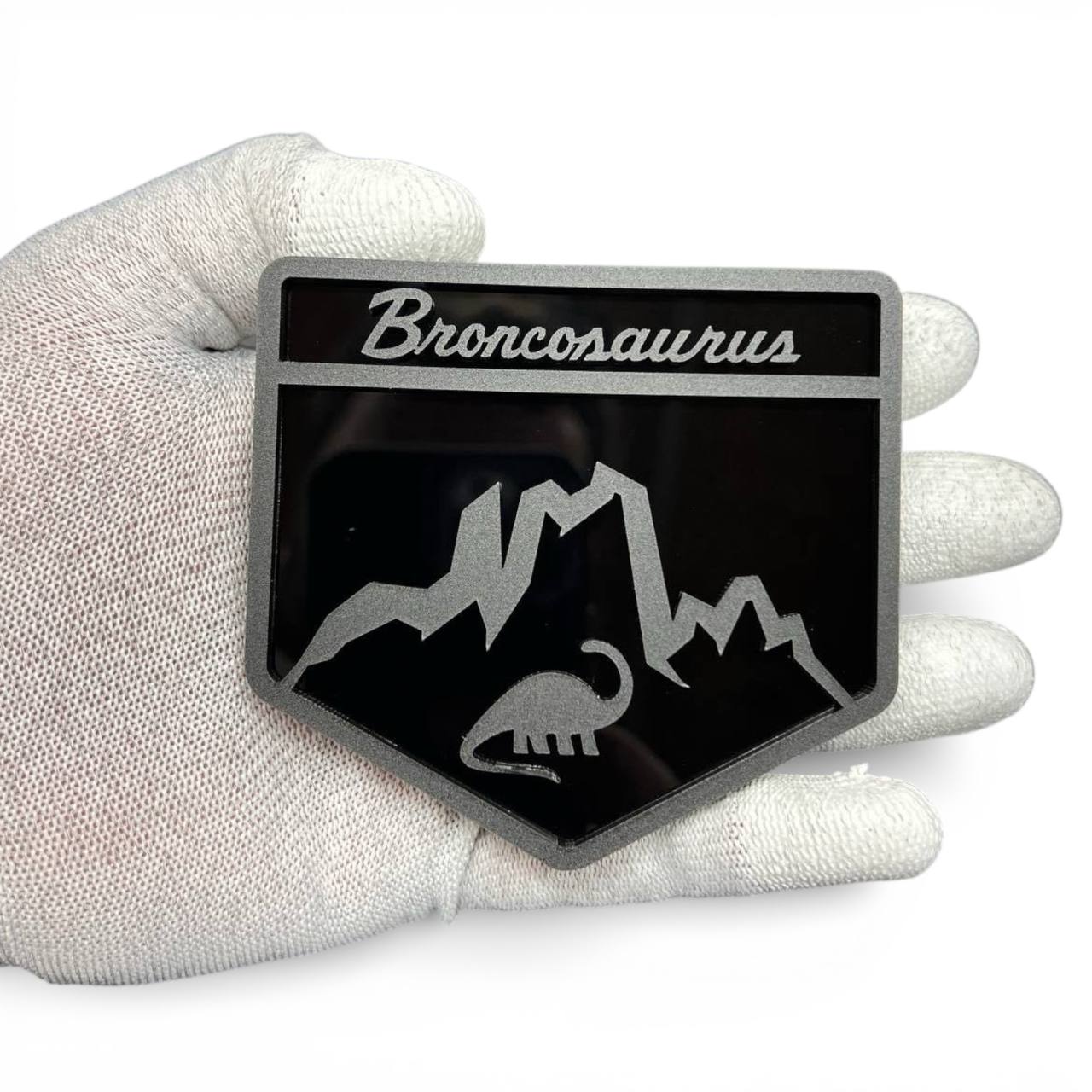 Broncosaurus badge for Ford Bronco made from black and silver acrylic, custom dinosaur off-road emblem