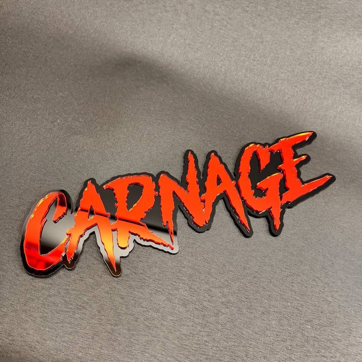 CARNAGE automotive text badge made from layered red and black acrylic