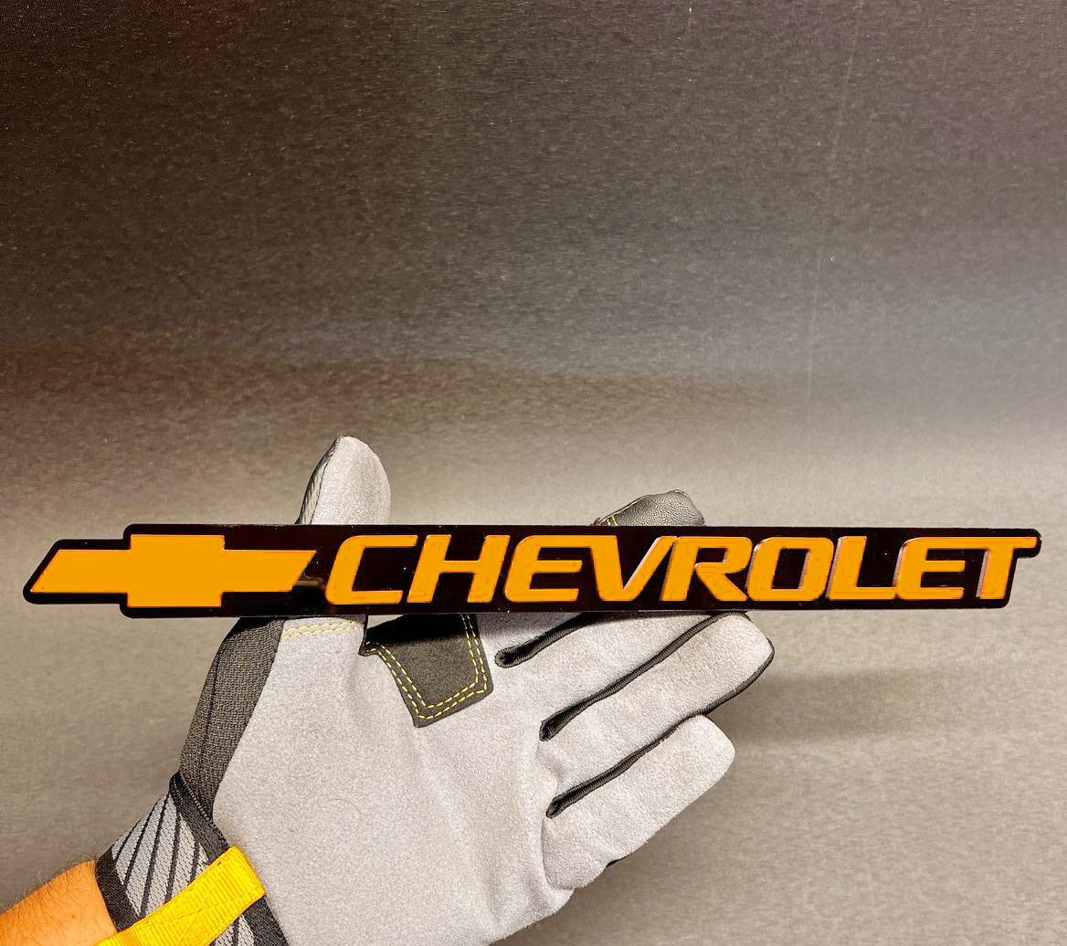 Orange Chevy Bowtie tailgate emblem for 1999-2006 Chevrolet trucks and SUVs.
