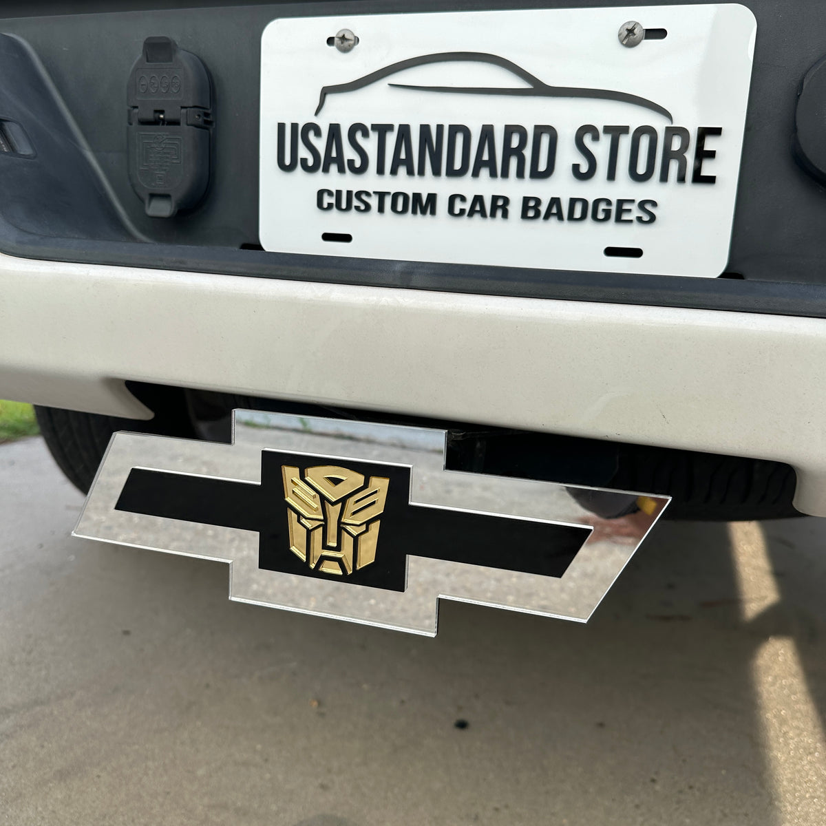 Chevrolet Bowtie hitch cover with silver finish and gold Autobot logo center