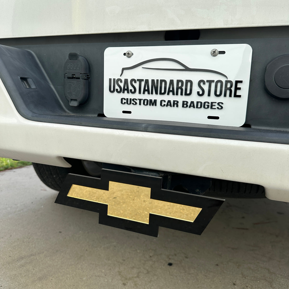 Gold Chevy Bowtie truck accessory hitch cover installed on rear receiver