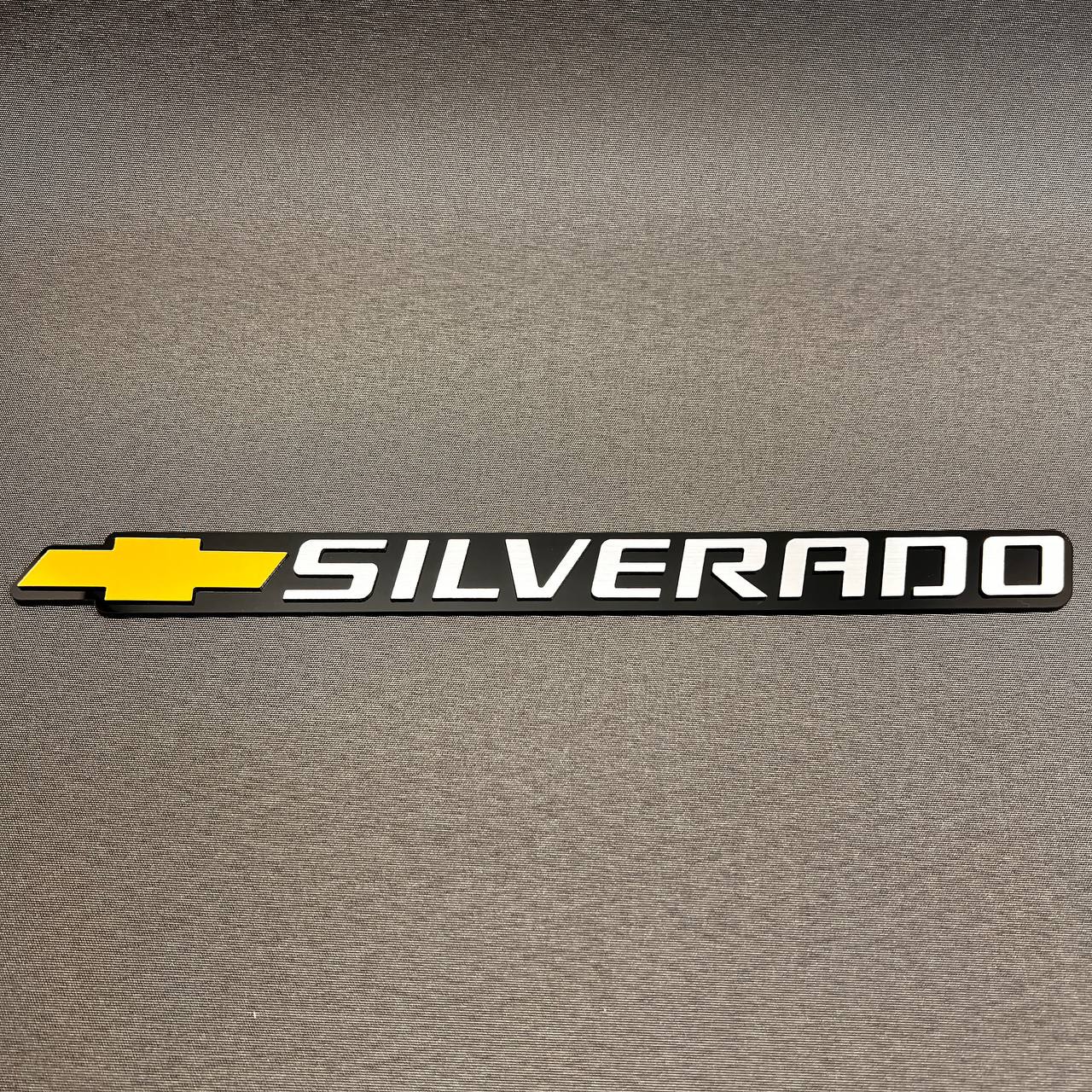 Gold Chevy bowtie Silverado badge with black background for tailgate installation.