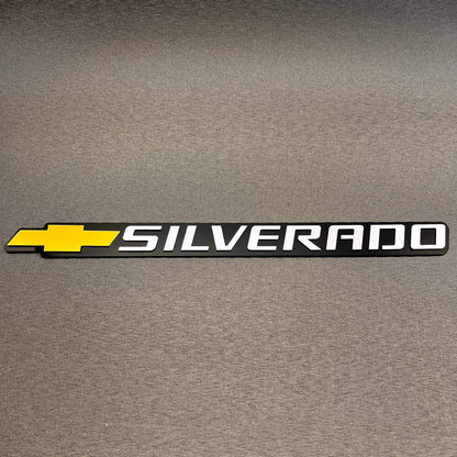 Gold Chevy bowtie Silverado badge with black background for tailgate installation.