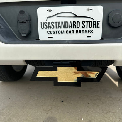 Gold Chevy Bowtie hitch cover emblem with black backing mounted on truck